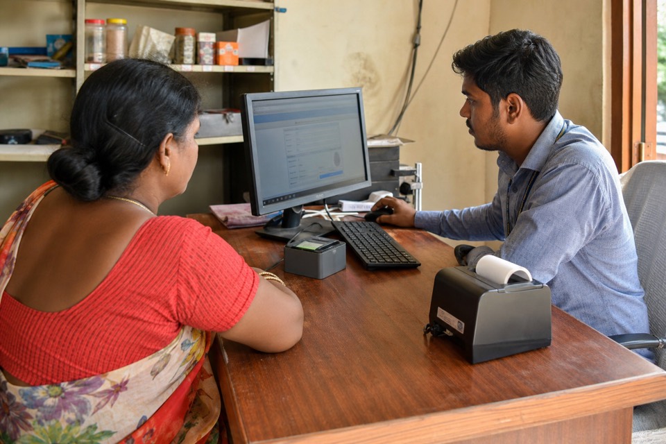 Banking correspondent helping a customer with digital banking at a CSP outlet